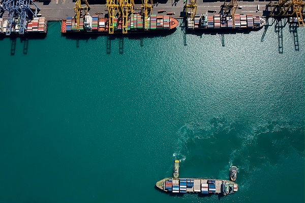 container-ship-tugboat-sailing-sea-commercial-port-working-crane-bridge